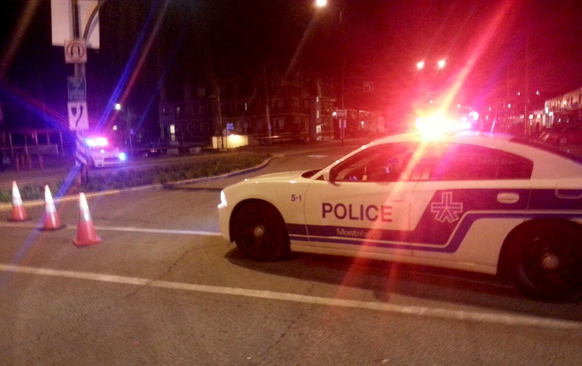 A Montreal police car blocks off a street near Pierre Trudeau International Airport after the discovery of a potential explosive device in the carry-on luggage of a 71-year-old man headed to Los Angeles.