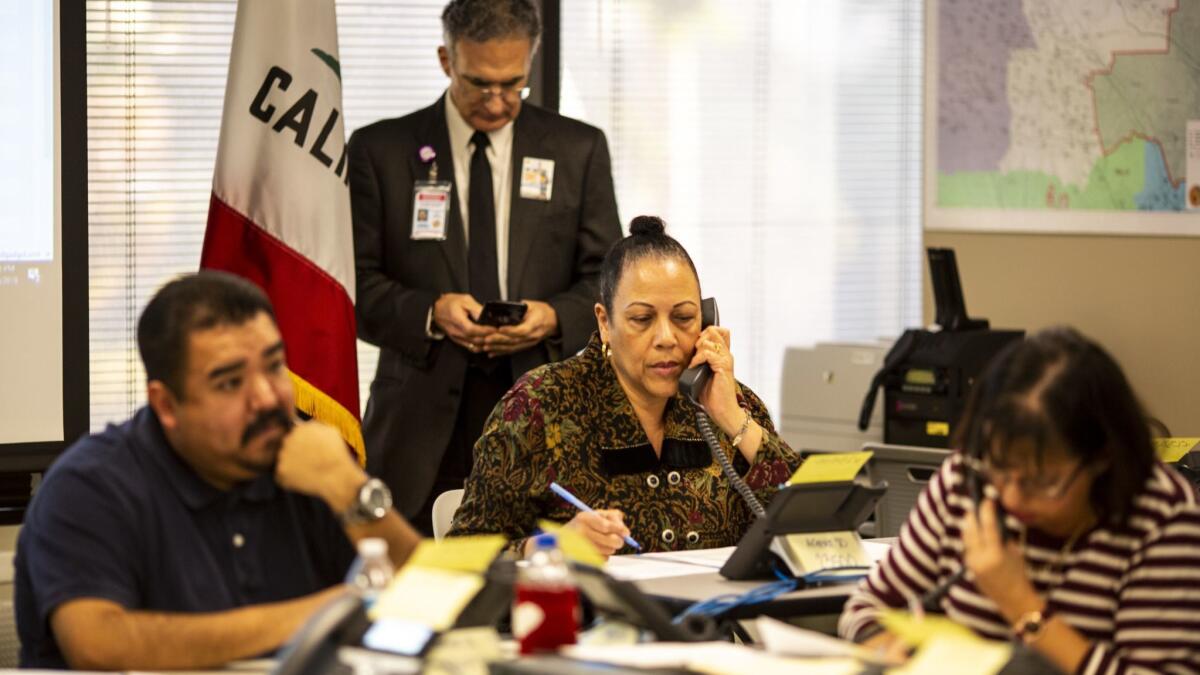 School district employees Robert Partida, Lisa LaCoste Clayton and Katherine Zdyvewl work at emergency call center set up at LAUSD headquarters to answer questions about a possible strike.