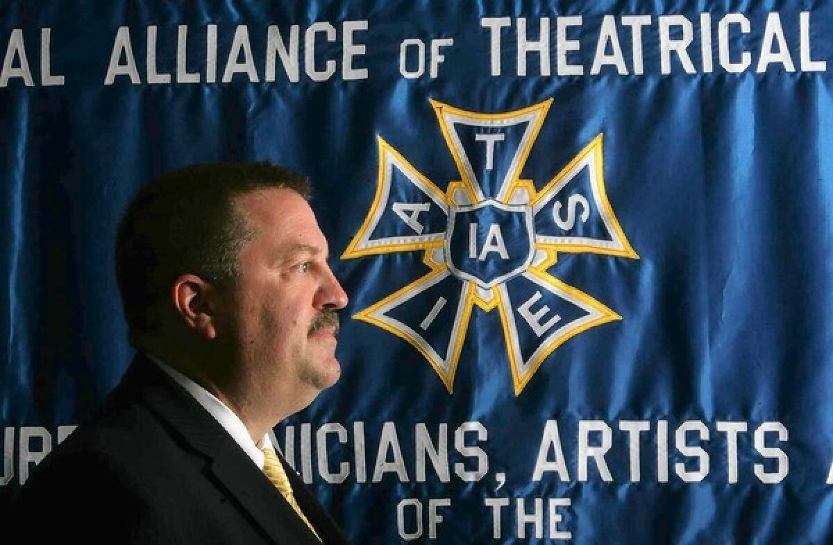 IATSE President Matthew Loeb stands in front of a union banner.