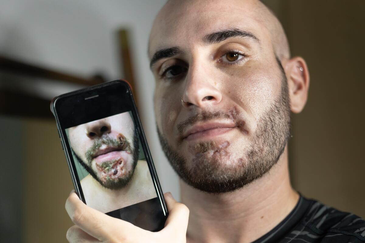 A man holds up a phone with a picture on it.