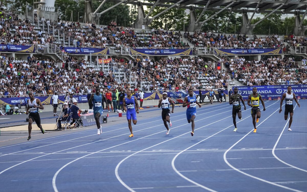 South Africa's Luxolo Adams, left, leads the back to win the 200 meters men during the Diamond League athletics meeting at Charlety stadium in Paris, Saturday, June 18, 2022. (AP Photo/Michel Euler)