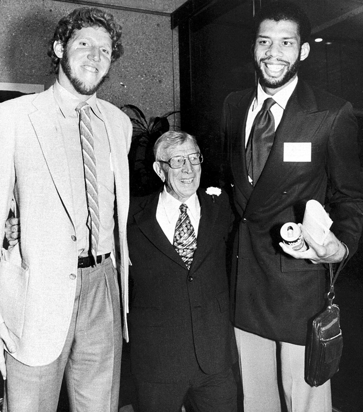 加州大学洛杉矶分校 (UCLA) 前教练约翰·伍登 (John Wooden) 两侧是球星比尔·沃顿 (Bill Walton) 和卡里姆·阿卜杜勒·贾巴尔 (Kareem Abdul-Jabbar) 