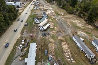 Homes and vehicles that were damaged in a flash flood from Hurricane Helene lie on the side of a road near the Swannanoa River, Tuesday, Oct. 1, 2024, in Swannanoa, N.C. (AP Photo/Mike Stewart)