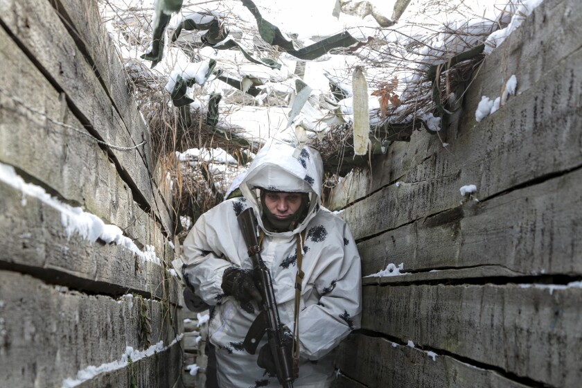 An armed man walks in a trench