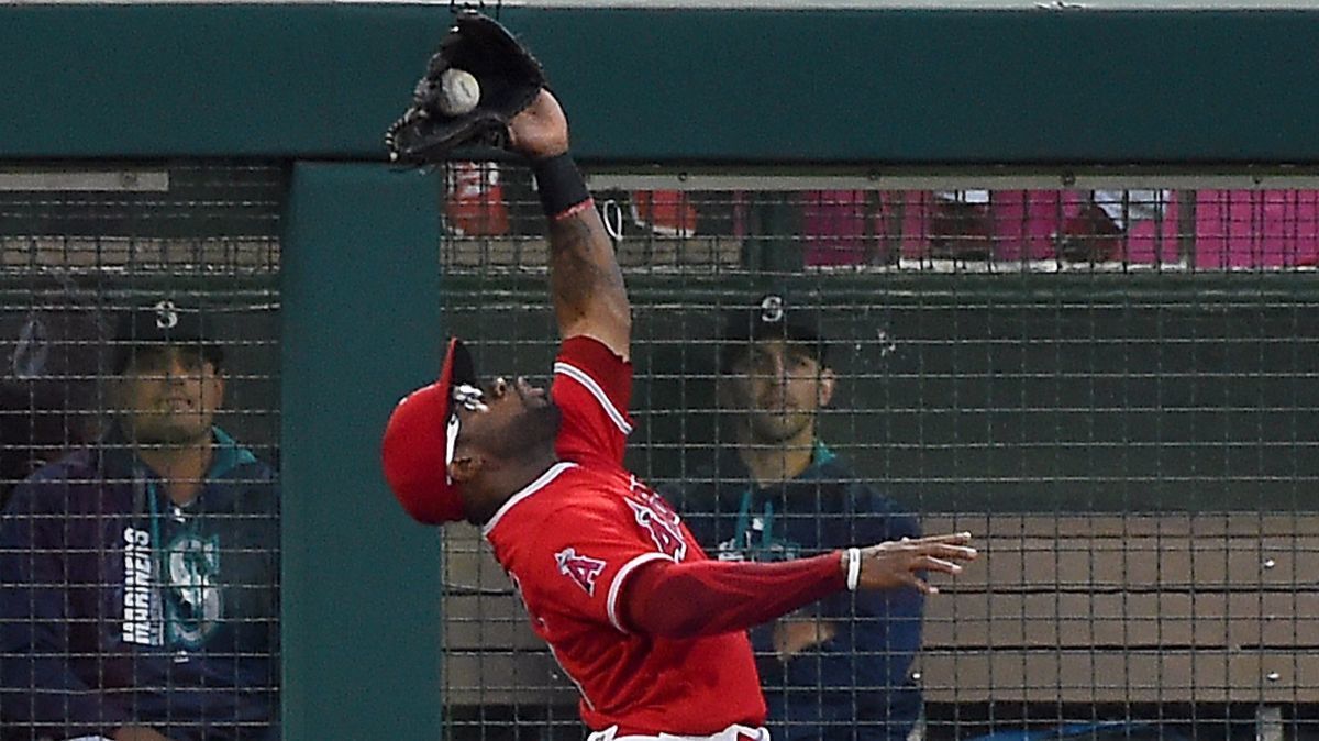 Angels outfielder Eric Young Jr. makes a leaping catch at the bullpen fence on a fly ball by the Seattle Mariners' Robinson Cano in the third inning on Friday.