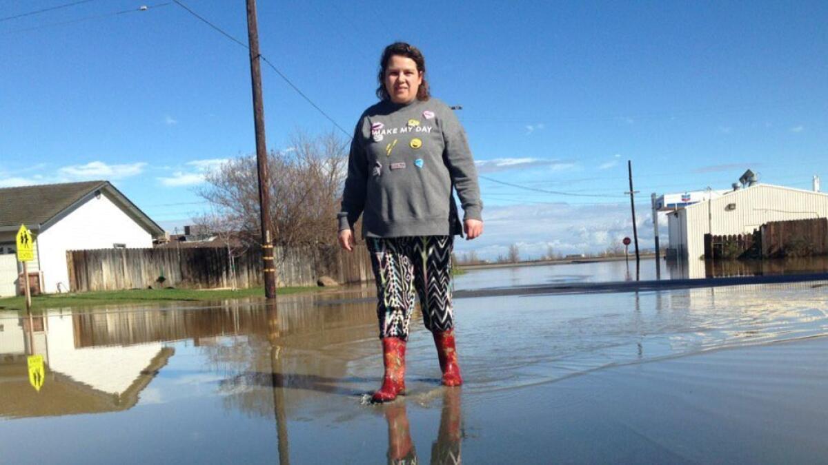 Blanca Velasquez was among many searching for dry ground Saturday in the flooded town of Maxwell, south of Oroville.