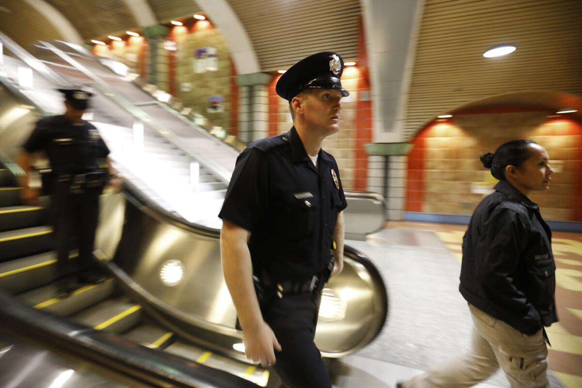 LAPD Officer Ian Cochran, center, and LAPD officer Yolanda Gutter walk into the subway platform in Hollywood. Gutter is a mental evaluation officer and part of the Homeless Outreach Partnership Endeavor.