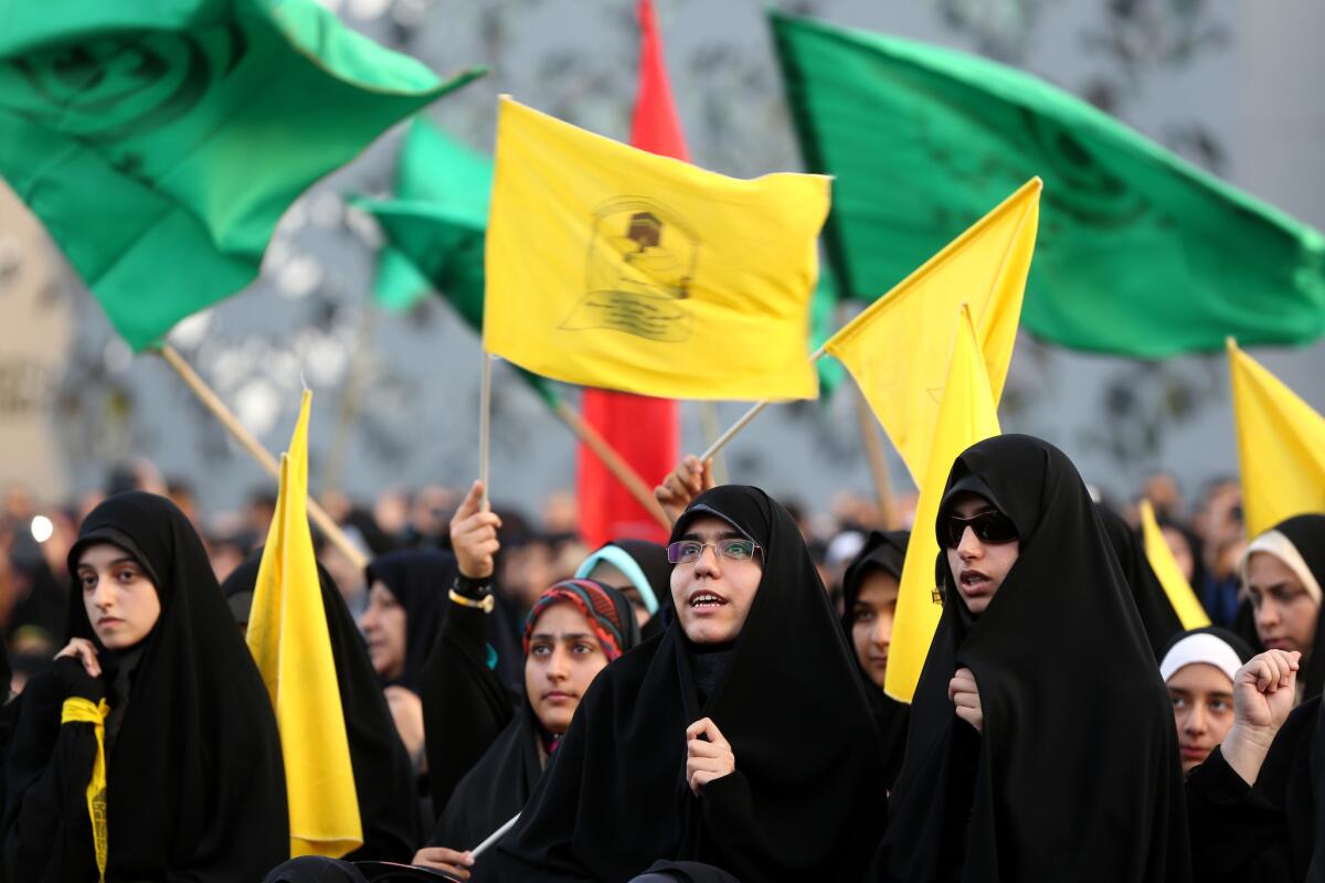 Iranian women wave Islamic flags while chanting against the militant Islamic State of Iraq and Syria movement during a rally in Tehran.