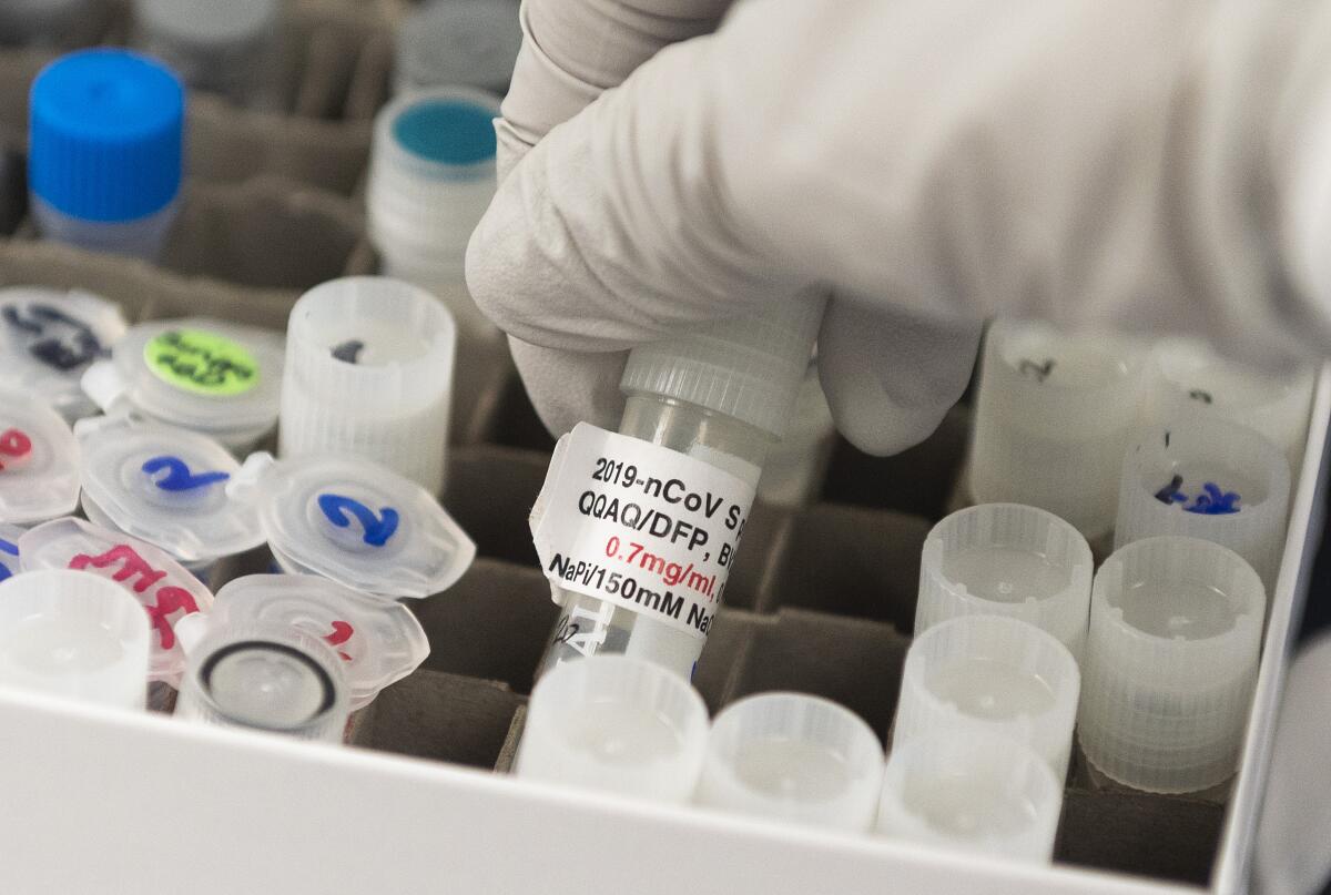 Dr. Nita Patel holds a vial with a potential vaccine at Novavax labs.