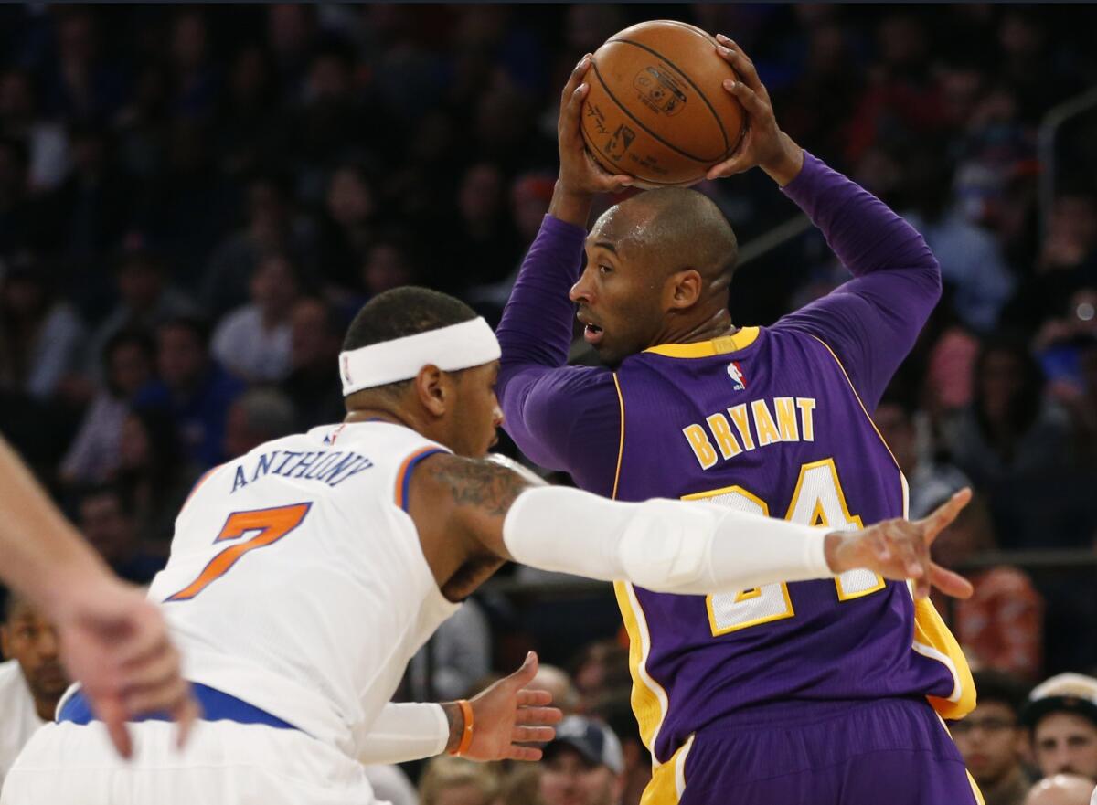 Lakers forward Kobe Bryant protects the ball as he's guarded by Knicks forward Carmelo Anthony in the first half Sunday.