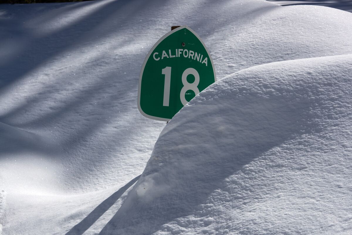 Many street signs are nearly covered as Big Bear Valley digs out from successive storms 