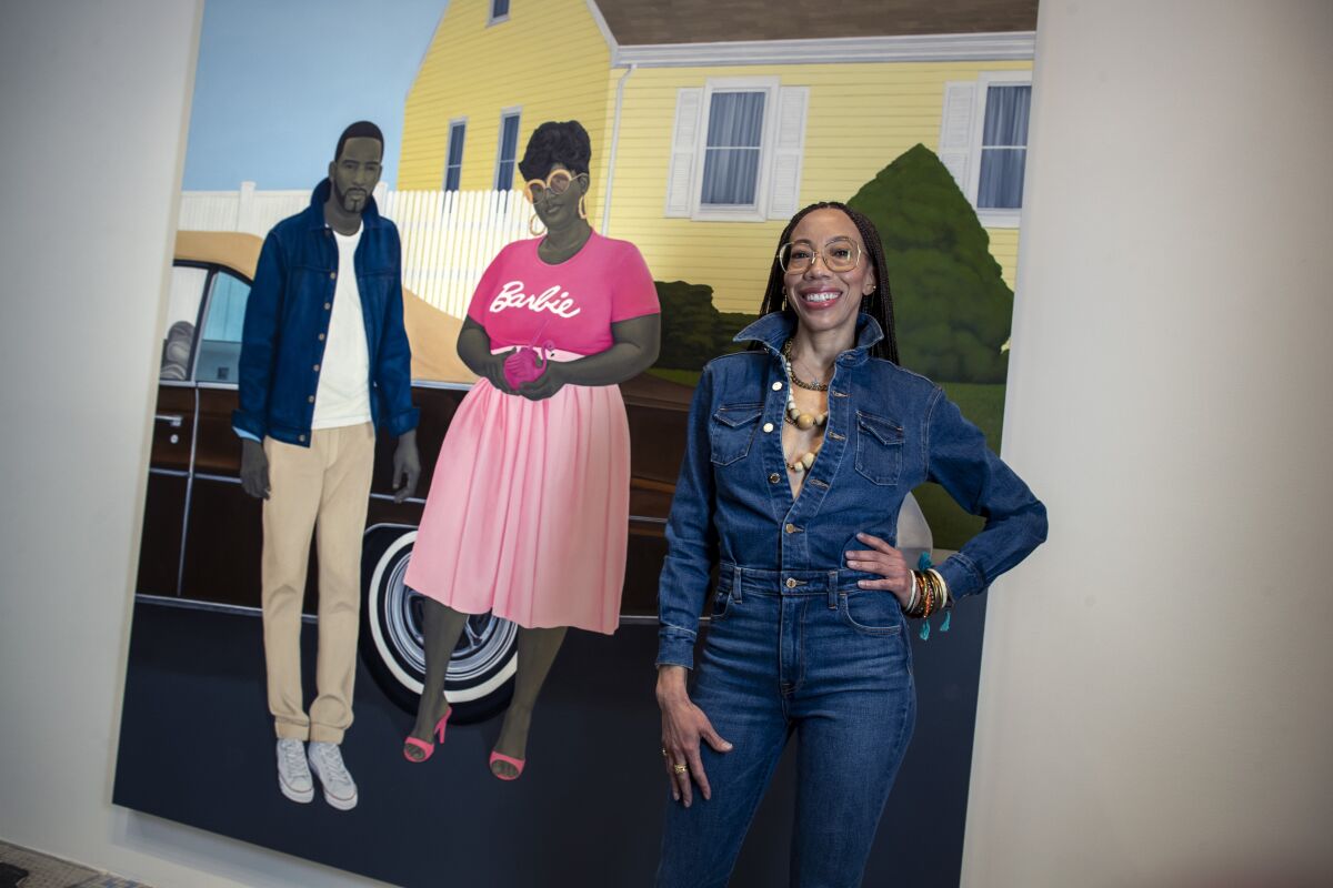 Artist Amy Sherald poses with her painting of a Black couple posed in front of their car