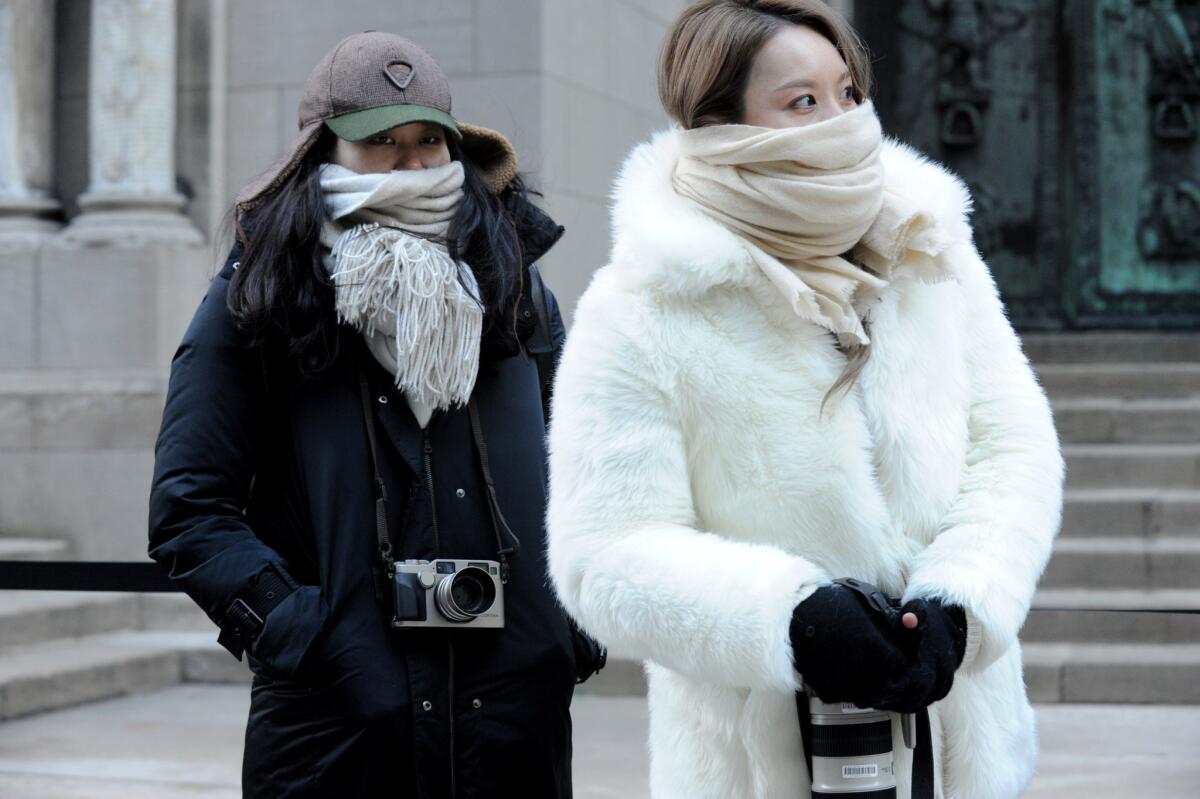 Street photographers brave the cold to photograph guests arriving for the Alexander Wang Fall 2016 show during Fashion Week in New York.