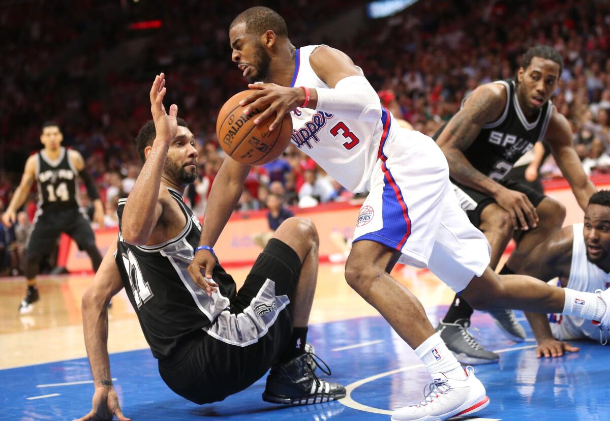 Chris Paul and San Antonio forward Tim Duncan go after a loose ball during Game 5 of the playoff series between the Clippers and Spurs. at Staples Center on April 28.