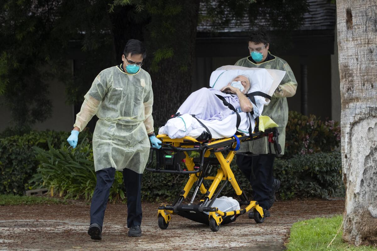 An 84-year-old COVID-19 patient is wheeled out of a nursing home 