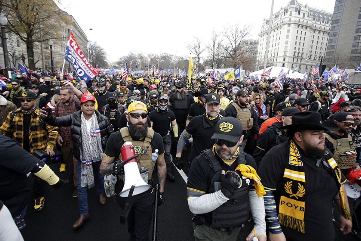 Supporters of President Trump, including Proud Boys in black and yellow, rally at Freedom Plaza in Washington.