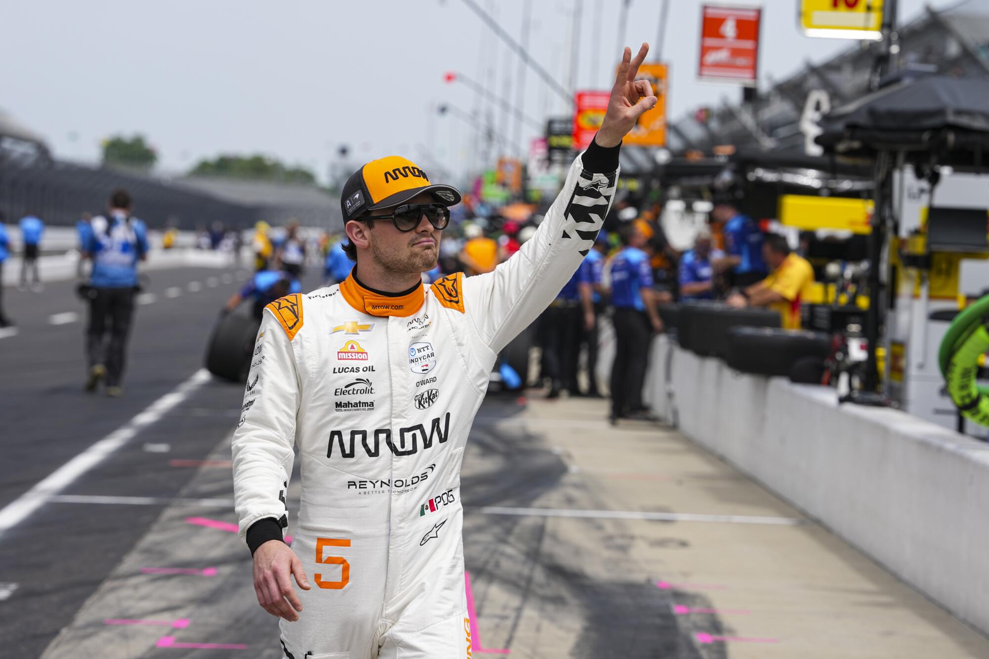 Pato O'Ward stands on the track and waves to fans before the start of Indianapolis 500 practice on Monday.