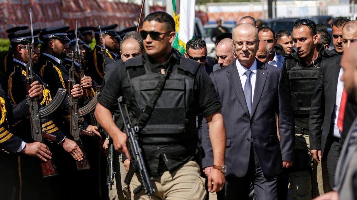 Palestinian Authority Prime Minister Rami Hamdallah, escorted by his bodyguards, is greeted by police forces of the Islamist Hamas movement upon his arrival in Gaza City on March 13.