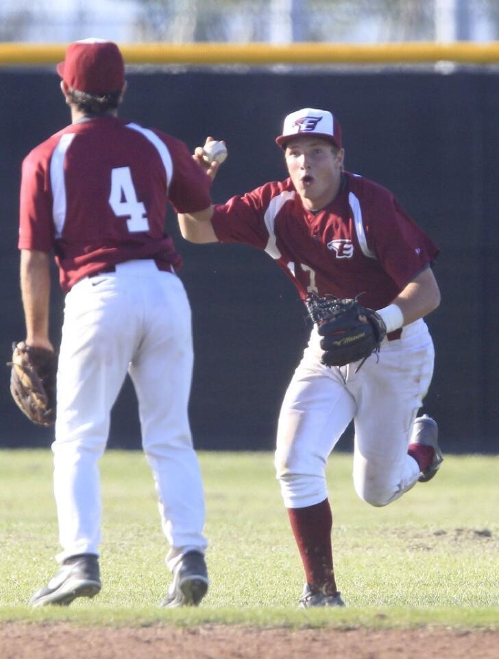 Estancia High's Jackson Letterman, right, shows teammate Zach Shafer, left, the ball after securing the last out to beat Costa Mesa, 2-0, on Wednesday in the second game of a three-game series.