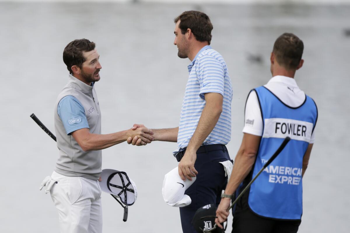 Andrew Landry shakes hands with Scott Scheffler, right, after winning The American Express golf tournament on the Stadium Course at PGA West.