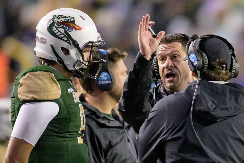 UAB coach Bryant Vincent, back right, talks with quarterback Dylan Hopkins during the first half of the team's NCAA college football game against LSU in Baton Rouge, La., Saturday, Nov. 19, 2022. (AP Photo/Matthew Hinton)