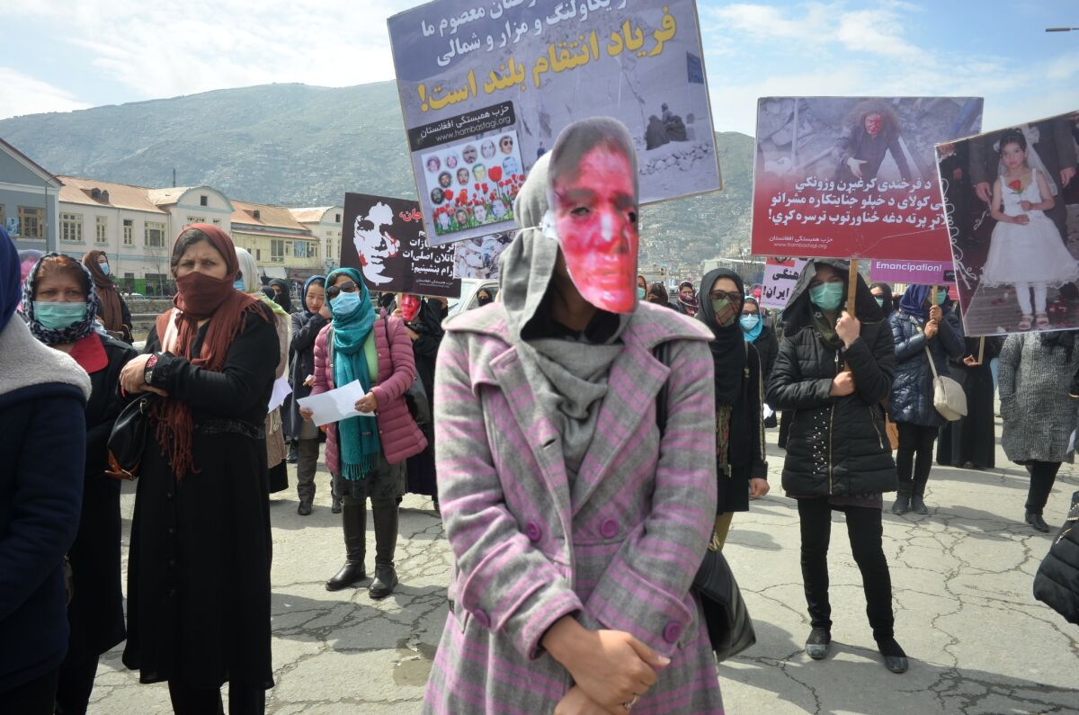 Afghans attending the dedication of a monument in Kabul honoring Farkhunda Malikzada wear masks depicting her bloody face.