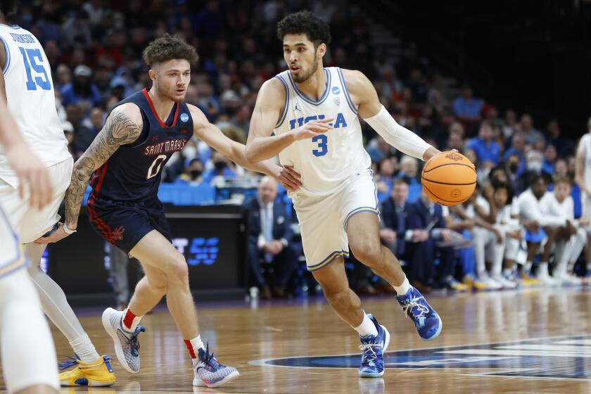 UCLA guard Johnny Juzang (3) drives around St. Mary's guard Logan Johnson (0).