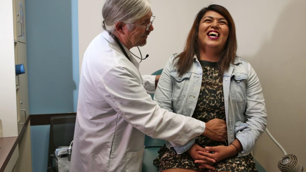 Alexa Vasquez, a transgender female, with physician assistant Lyle Cook at St. John's Well Child & Family Center in South L.A. A new report describes significant health disparities between transgender and gender-majority adults.