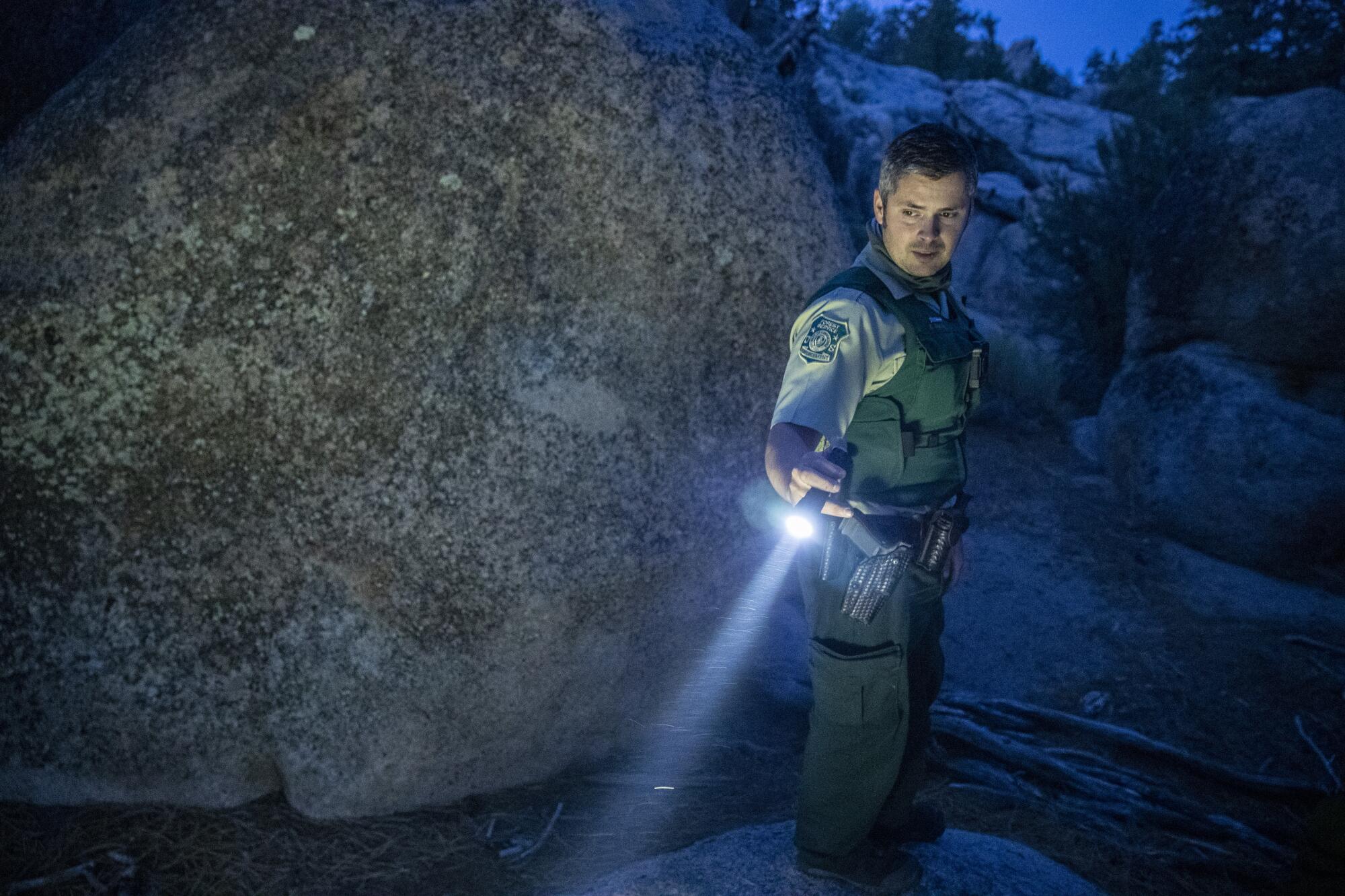  Forest service law enforcement officer Tyler Smith looks for evidence of illegal camping while on patrol 