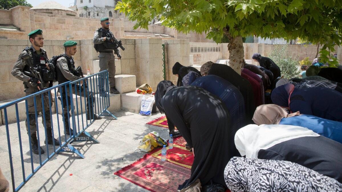 Palestinian women pray at the Lions Gate following an appeal from clerics to pray in the streets instead of inside the Al Aqsa Mosque compound, in Jerusalem's Old City on July 25, 2017.