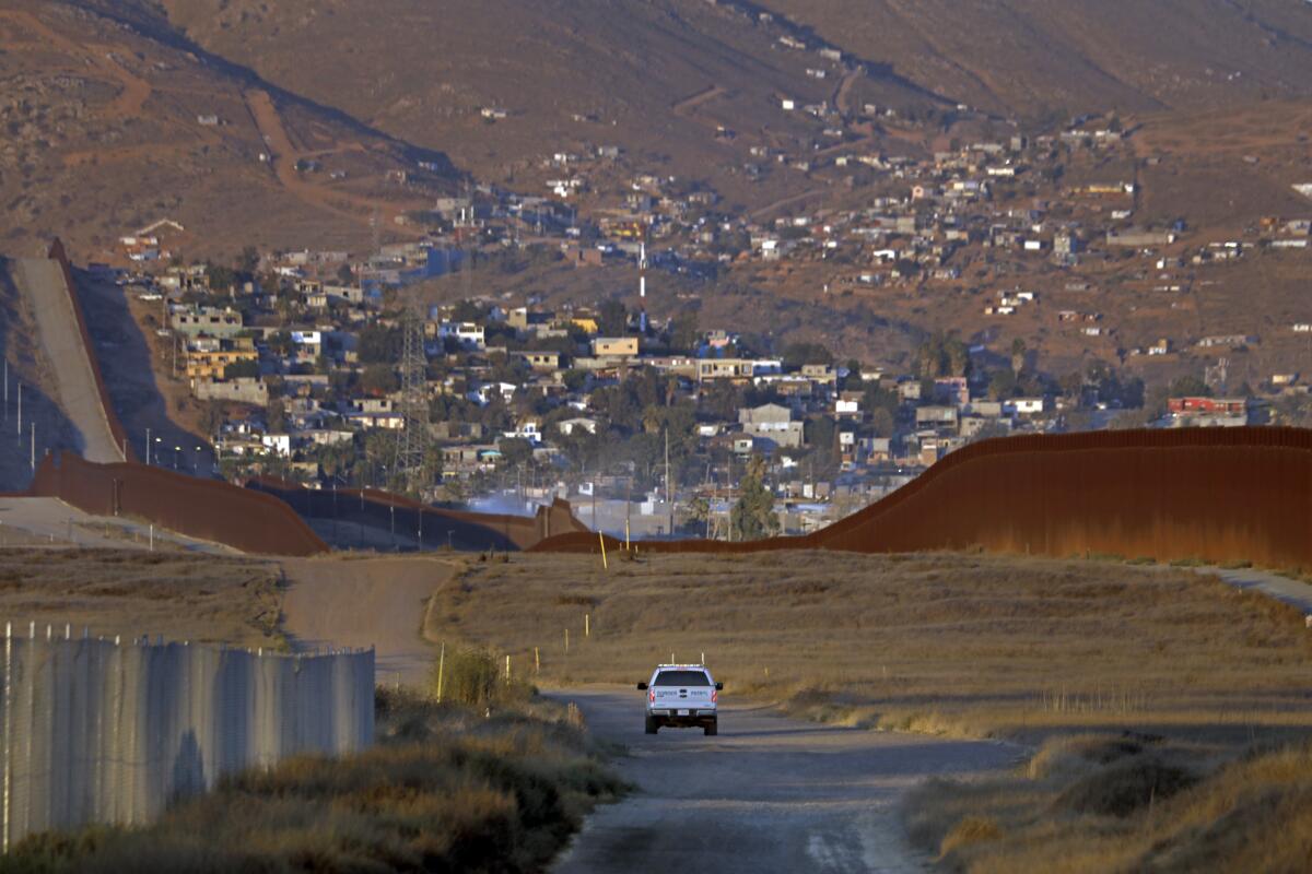 A U.S. Border Patrol agent drives along the U.S.-Mexico border east of Otay Mesa in San Diego on Aug. 10, 2022.