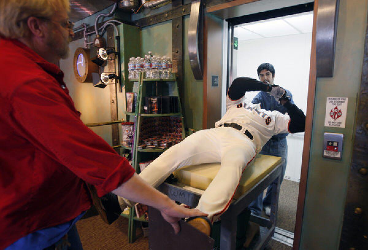 Curtis Huber, left, and Eric Valencia load the wax figure of Barry Bonds into an elevator at the Wax Museum at Fisherman's Wharf in San Francisco. The museum is closing its doors Thursday after more than 50 years.