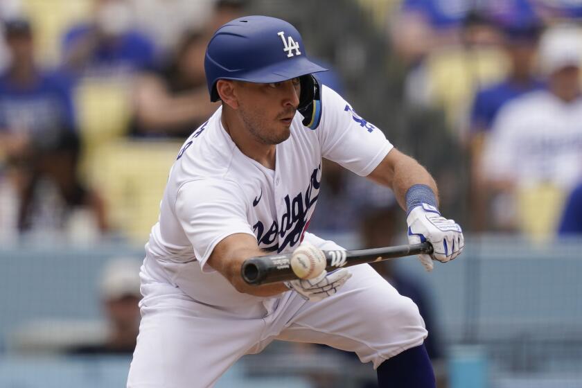 Los Angeles Dodgers' Austin Barnes bunts the ball leading to James Outman.