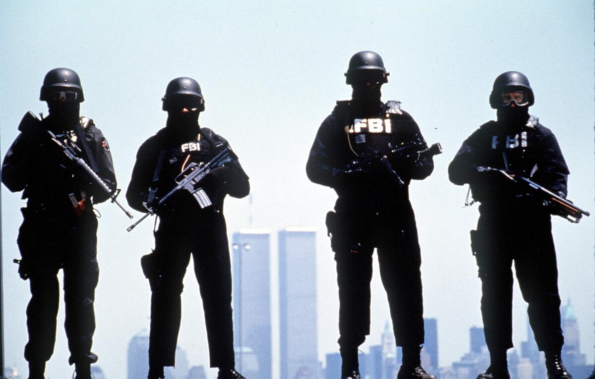A masked FBI SWAT team poses for the photo.