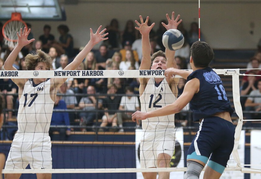 Newport Harbor High's Dayne Chalmers (12) blocks Corona del Mar's Bryce Dvorak (18) with help from Alec Patterson (17) in the Battle of the Bay rivalry on March 29.