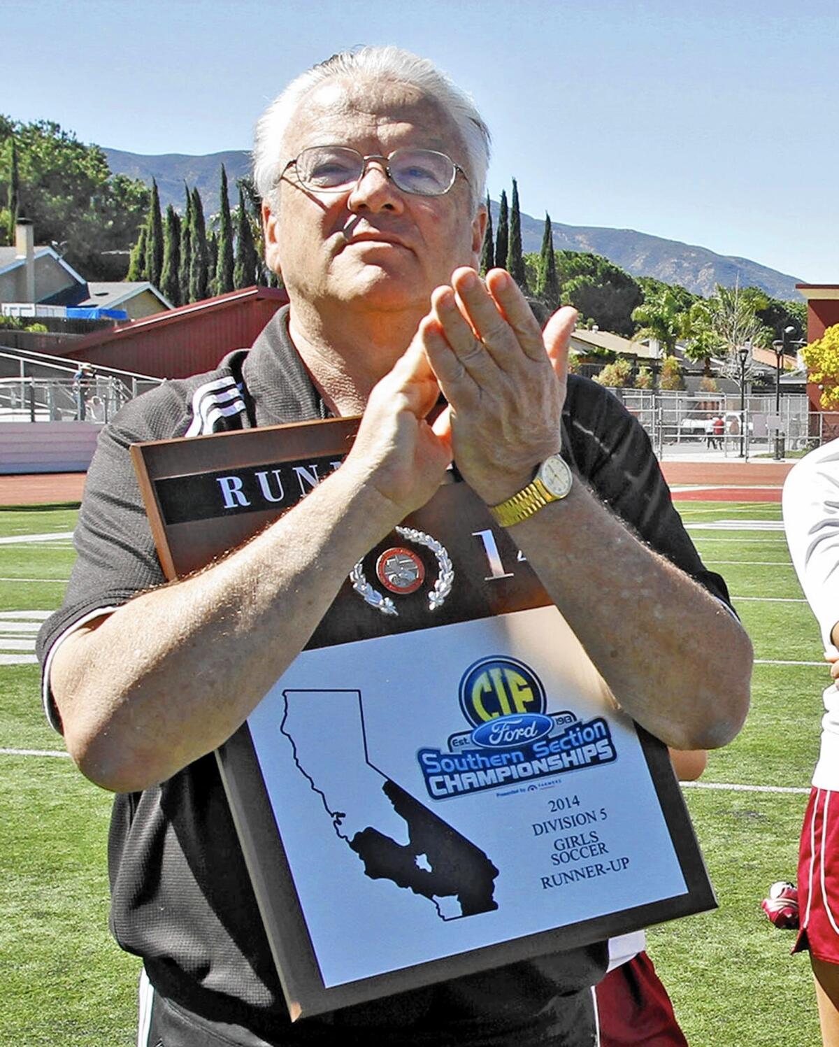 La Cañada High School soccer coach Louie Bilowitz holds the runner-up trophy after playing in the CIF SS Girls Div 5 final match vs. St. Margaret's High School at Corona High School in Corona, Ca., on Saturday, March 8, 2014.