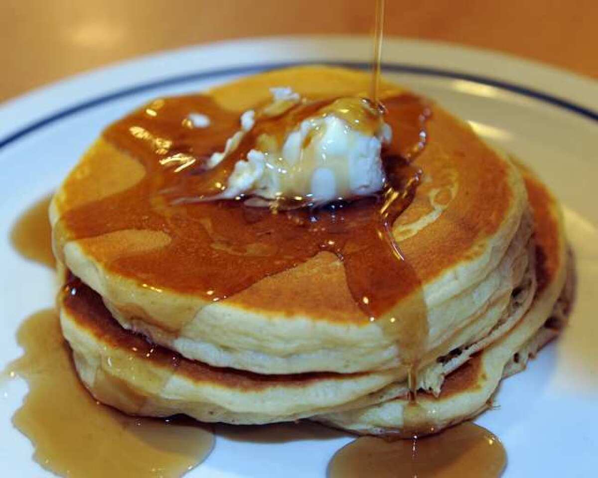 Maple syrup runs down the side of a short stack of three pancakes at an IHOP. Parent company DineEquity reported a profit for its first quarter.