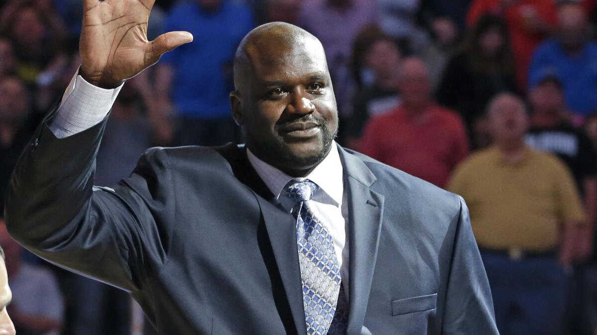 Shaquille O'Neal waves to fans while being honored during a game between the Orlando Magic and Detroit Pistons on March 27, 2015.