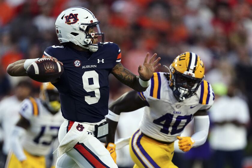 Auburn quarterback Robby Ashford (9) throws for a touchdown as LSU linebacker Harold Perkins Jr. (40) rushed in in the first half of an NCAA college football game, Saturday, Oct. 1, 2022, in Auburn, Ala. (AP Photo/John Bazemore)