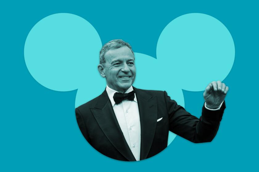 a man in a tux waves from inside the silhouette of the Disney mouse icon