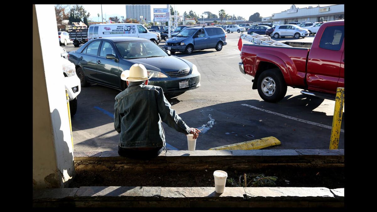 A 70-year-old man who lives in his vehicle has a cup of coffee in Costa Mesa. 