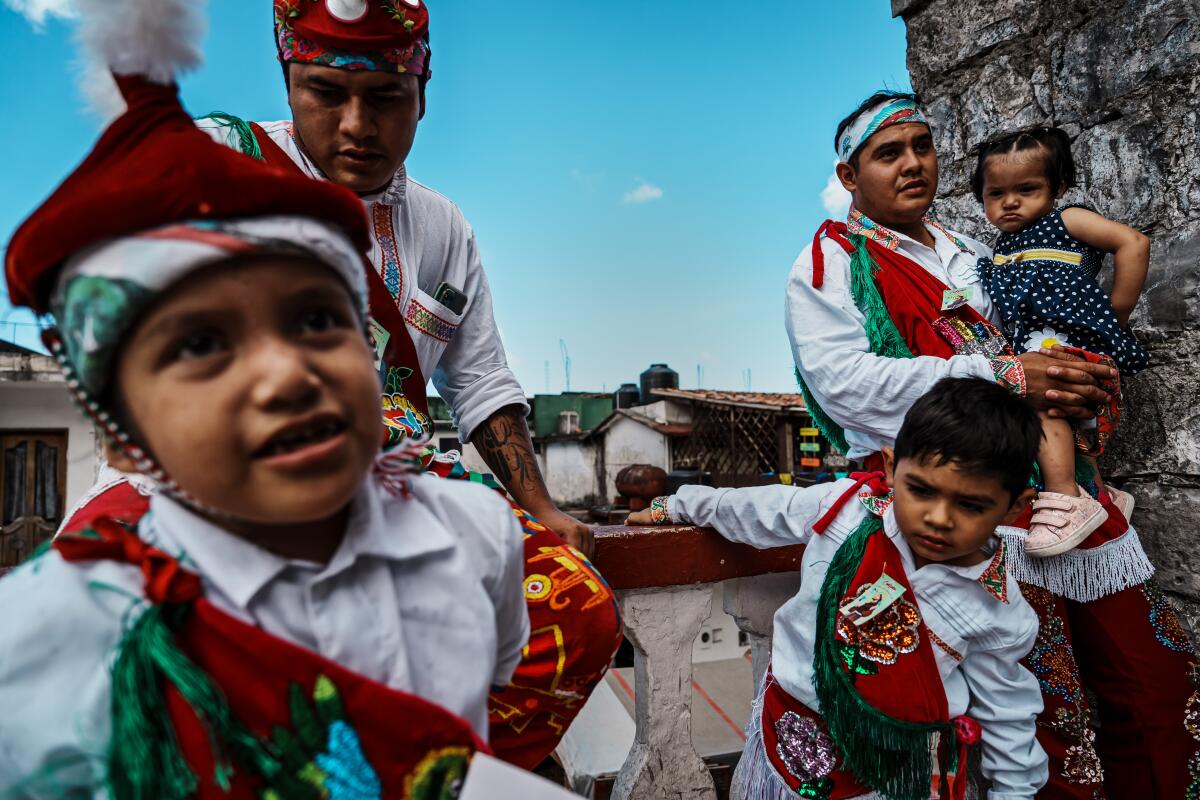 Voladores Ricardo García, left, and his cousin Carlos Fernández, right, are joined in Cuetzalan by children also dressed as voladores.