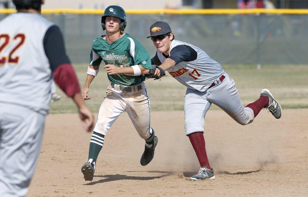 Costa Mesa High's Dylan Schafer gets caught in a rundown by Estancia's Brian Rodriguez.