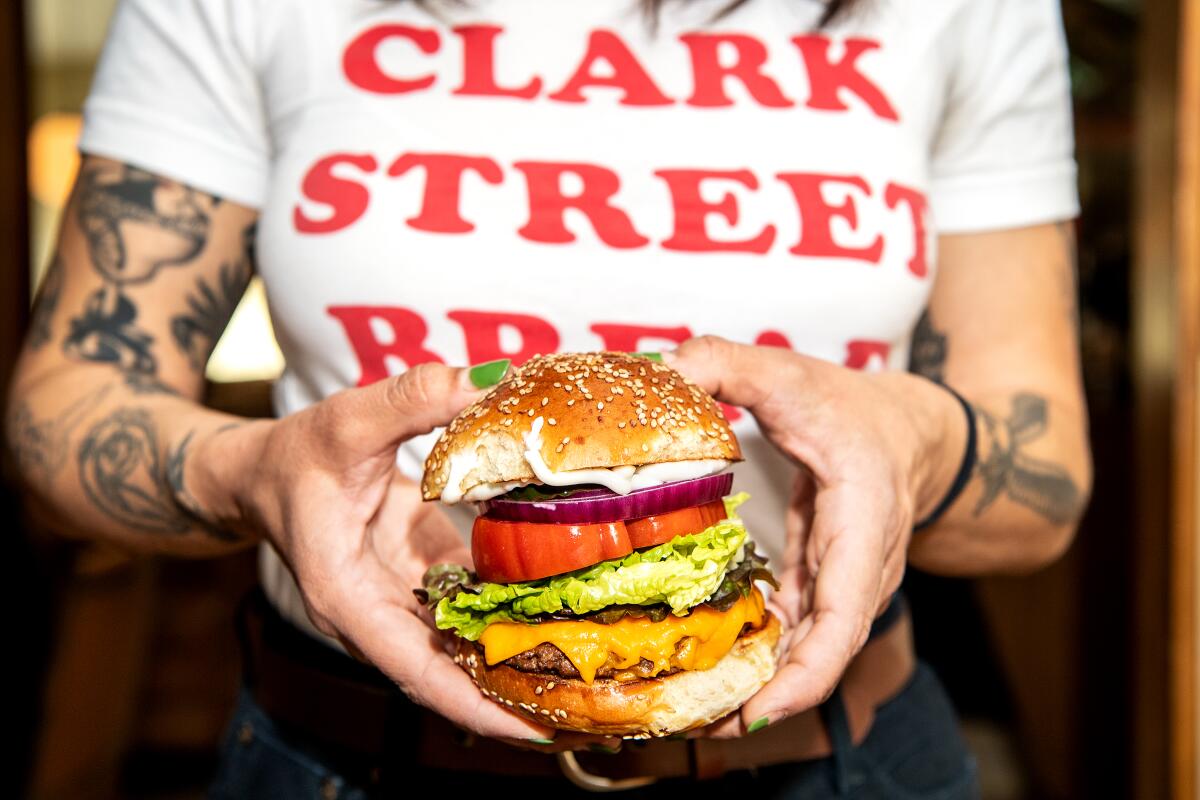Manager Bianca Perez holds the vegan burger at Clark Street Diner.