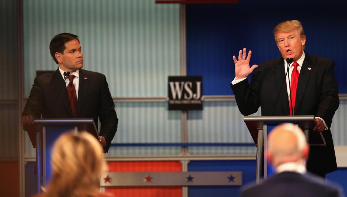 Presidential candidate Donald Trump (R) speaks while Sen. Marco Rubio (R-FL) looks on while Donald Trump looks on during the Republican Presidential Debate at the Milwaukee Theatre.