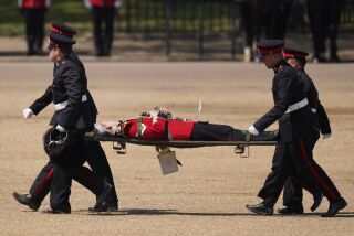A trombone player of the military band is carried out on a stretcher after a faint during the Colonel's Review, the final rehearsal of the Trooping the Colour, the King's annual birthday parade, at Horse Guards Parade in London, Saturday, June 10, 2023. (AP Photo/Alberto Pezzali)