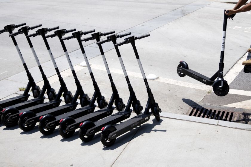 James Wilson lines up electric scooters on a street corner after charging them overnight in Atlanta, Friday, June 28, 2019. "It's a good little side hustle," said Wilson who has found greater fortune in charging the scooters than his old job of driving a truck. Supporters of the scooters, which have popped up in cities across the country, say they're great for short trips, but critics say they're a nuisance and can be dangerous to their drivers, pedestrians and motorists. (AP Photo/David Goldman)