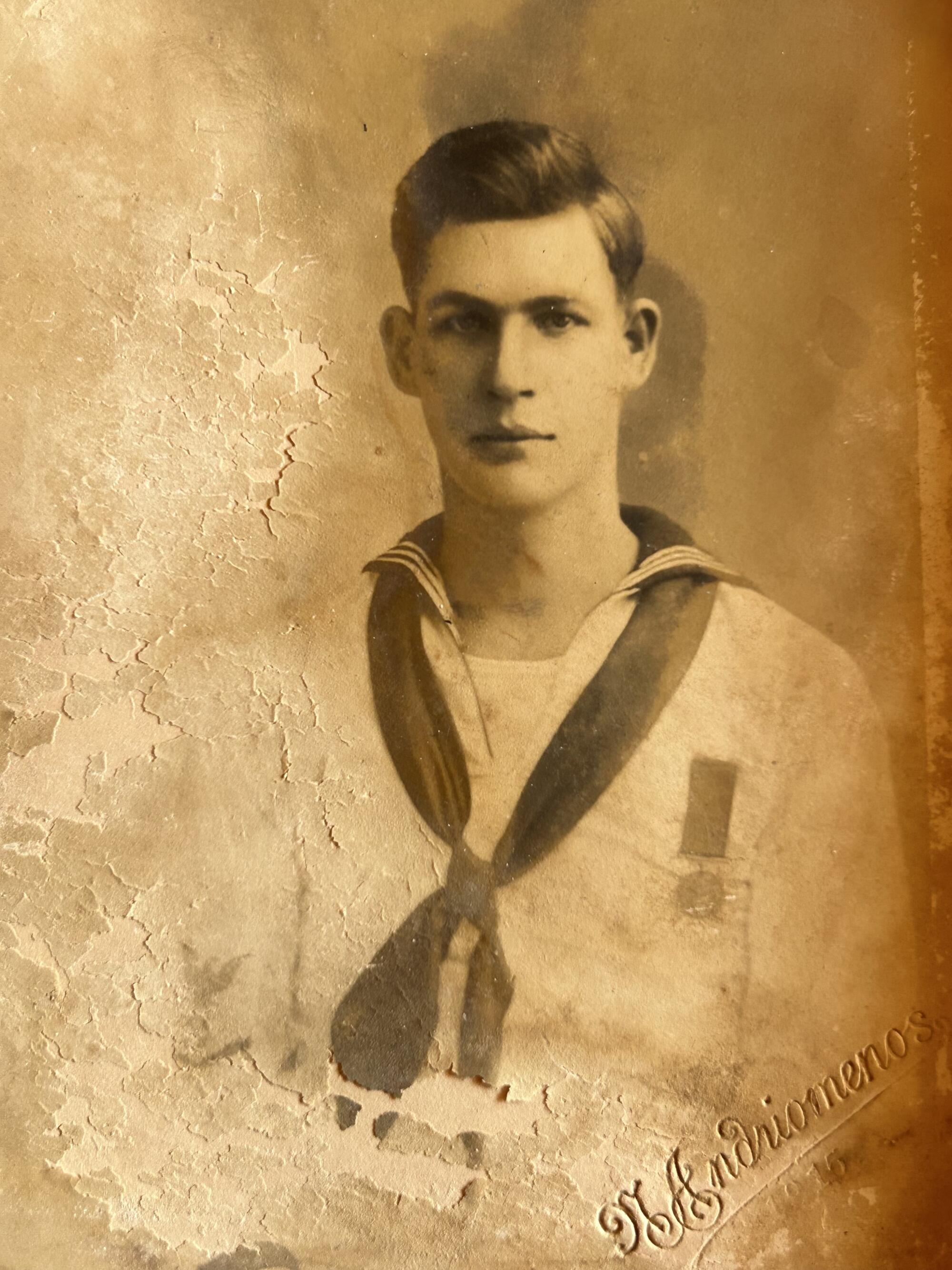 A sepia-tone portrait of a young man in an old-fashioned sailor suit