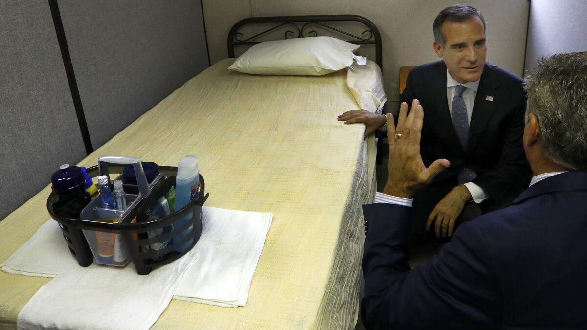 Los Angeles Mayor Eric Garcetti, left, and Executive Director of The People Concern John Maceri, right, at a temporary shelter trailer facility in El Pueblo in Los Angeles on Sept. 5.