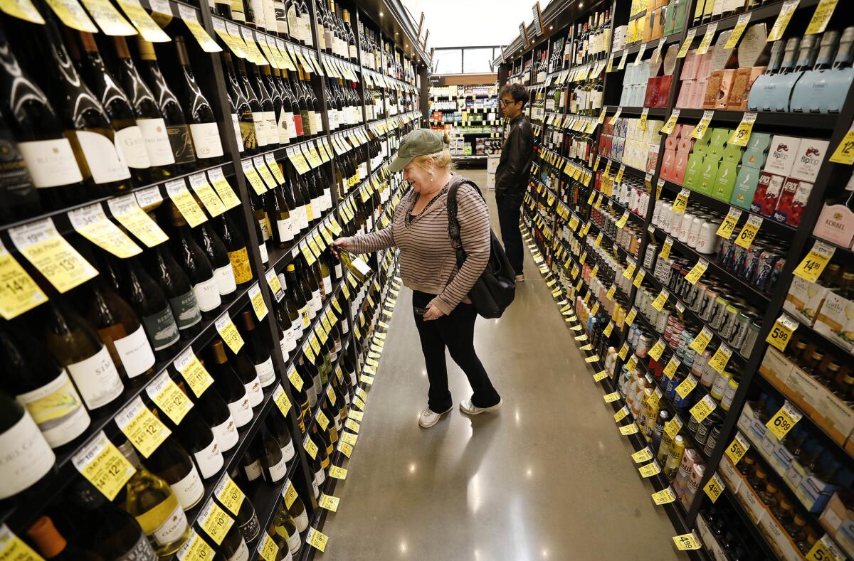 Avalon resident Rhonda Talsky looks through the wine selection at the new Vons Market on Catalina Island. (Al Seib / Los Angeles Times)